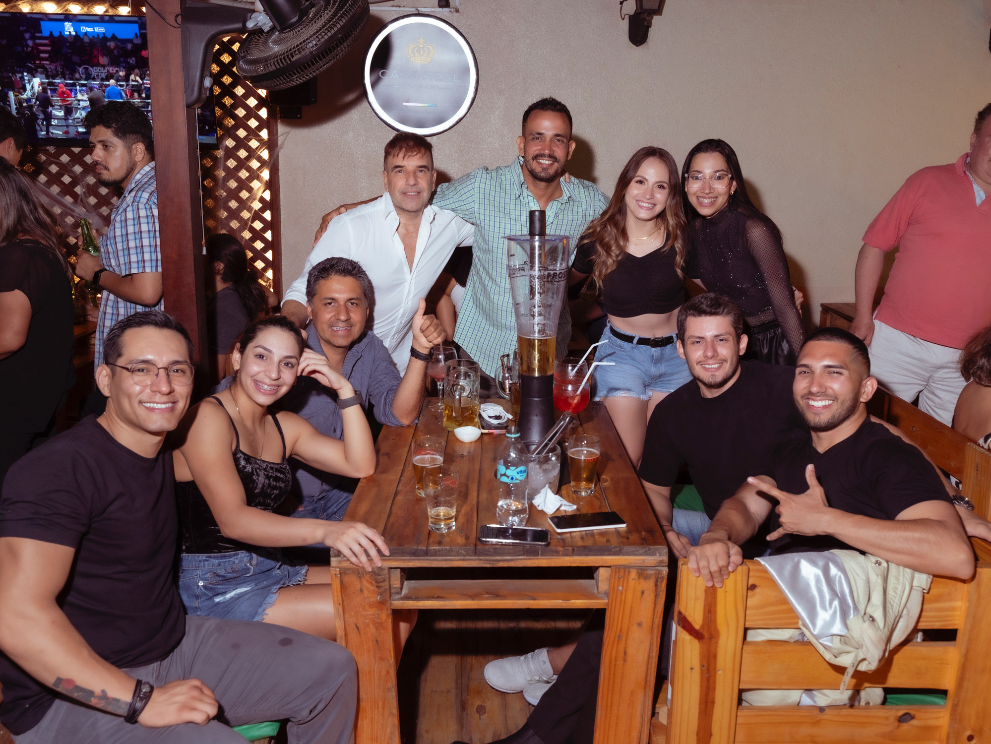 Amigos à mesa com torre de chopp no salão