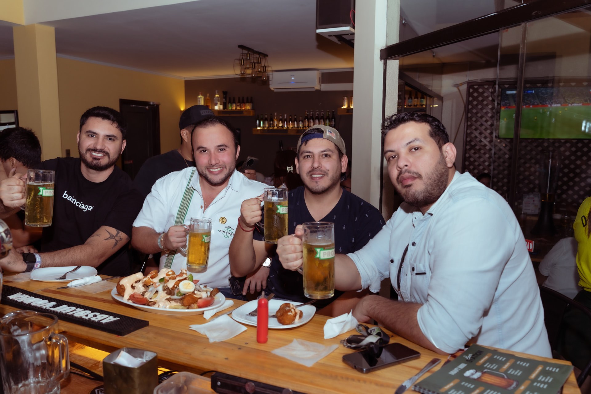 Clientes compartilhando cervejas e petiscos